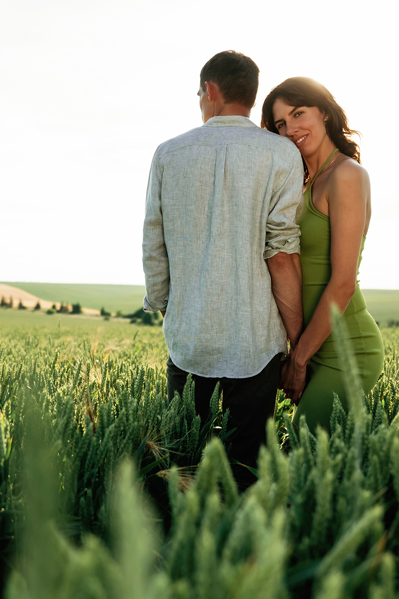 Under the sunlight, enjoying each other. Lovely couple are on the agricultural field together.